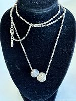 Sterling silver necklace with two sparkling Pandora beads displayed on a black mannequin bust.