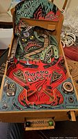 Colorful cardboard Pinbox 3000 Swamp Quest pinball game inserted and assembled showing detailed graphics and playfield