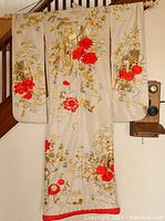 Front full view of kimono showing ivory fabric and red floral embroidery