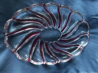 Top-down view of the oval Mikasa crystal serving tray showing red candy cane stripes and scalloped edges