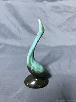 Photo of vintage mid-century modern Blue Mountain Pottery crane figurine in green drip glaze with visible neck repair, showing full front profile and ceramic base