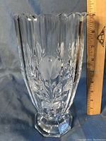 Clear crystal vase with etched floral design, scalloped rim edge and hexagonal base, shown next to ruler for size reference (about 9 inches tall).