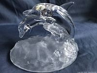 Clear glass dolphin family figurine with two dolphins jumping over textured base, side angle