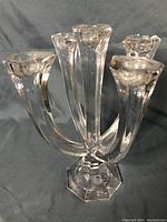 Front angle image of the clear glass five-arm candelabra showing all candle holders and octagonal base.