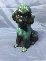 Front angled view of vintage Blue Mountain Pottery ceramic poodle figurine with green drip glaze.