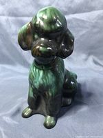 Front and side view of a Green Drip Glaze ceramic poodle figurine by Blue Mountain Pottery showing detailed fur texture and glossy glaze finish.