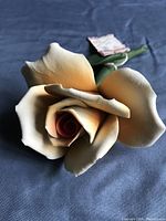 Close-up of the yellow and peach shaded porcelain rose showing detailed petals and texture.