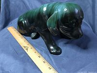Green glazed ceramic puppy dog figurine placed beside a ruler showing about 12 inches in length.