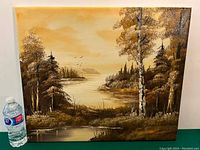 Oil on canvas landscape painting showing river, trees, and hills with birds in sky, water bottle shown for scale.