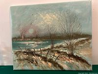 Front view of the oil painting showing the winter landscape with trees, river, and a rustic wooden fence under a cloudy sky with a large sun or moon.
