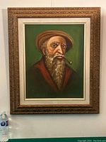 Framed oil on canvas painting of an older man with beard and hat, pipe in mouth.