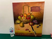 Full view of the oil painting showing the basket of fruit and surrounding still life elements.