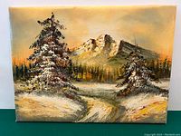 Full view of the oil painting showing snow-covered pine trees, a path, and mountains in the background with an orange sky.