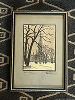 Full view of framed etching showing a winter landscape with trees and church steeple.