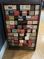 Wooden display frame with 66 matchbooks from vintage Las Vegas casinos and hotels arranged in 6 rows