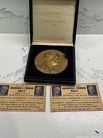 Photo of commemorative coin in presentation box with rally tickets displayed in front.