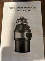 User manual for the food waste disposer showing the product image and titled 'FOOD WASTE DISPOSER USER MANUAL'.