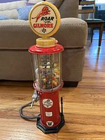 Front view of red Gilmore gas pump style beverage dispenser filled with marbles.