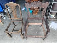 Pair of antique wooden chairs without upholstery, showing frames and carved details, one armless and one with armrests.