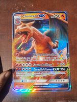 Front view of oversized Charizard GX Pokémon card with holographic foil and attack details shown