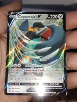 Photo showing full art Copperajah V Pokemon card with holographic foil and detailed artwork.