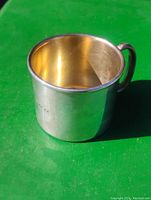 Silver baby mug with gold wash interior, showing the inside gold wash and silver exterior.
