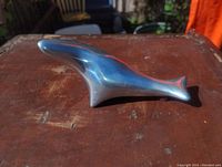 Front and side view of the smooth, polished aluminum seal sculpture.