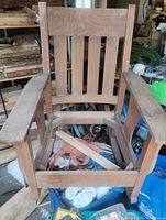 Full view of antique Mission oak rocking chair showing slatted back, square arms, and open seat frame without fabric.