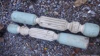 Pair of antique wooden furniture legs with fluted design, shabby chic paint finish in blue and white, placed on gravel.