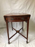 Full front view of the antique wooden side table showing single drawer with dual metal handles and intricate front marquetry.
