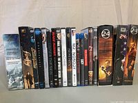Front view photo of DVDs showing titles including Underworld Legacy Collection, Firefly, Unbreakable, Hide and Seek, Blade Runner, Final Fantasy Spirits Within, The Skin I Live In, Machine, Serenity, Mr. Nobody, Scarlet Grin, and multiple 24 seasons.
