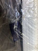 Close-up photo showing Secretland brand label on the mattress wrapped in plastic.