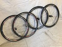 Two pairs of road bike wheels on a white sheet, showing Easton and Velomax branded rims.