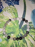 Quartz crystal bracelet on floral fabric showing bead details and elastic band.