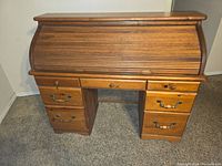Front view of the closed roller top desk showing six drawers and three small drawers on top center