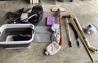 Photo showing Miele vacuum cleaner, mop, cleaning towels, floor mats, and mop handles.