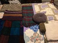 Photo showing overall collection of blankets, throws and cushions including Biederlack blankets and wool tartan blanket