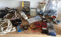 Overview of lot showing extension cords, tape, wiring devices, plumbing fittings, and multimeters.