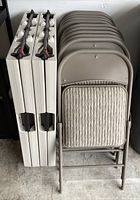 Side view showing two light beige rectangular folding tables stacked vertically with foldable legs.