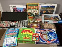 Full lot of poker chips in metal case with cards, dice, several board and card games, puzzle boxes and additional game items