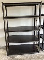 Front view of black metal shelving unit showing all 5 shelves and sturdy frame.