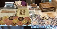 Overview of colorful kitchen and dining items on a table with placemats, runner, napkins, trays and coasters