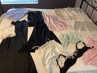 Photo showing all lingerie and nightgown pieces laid out on a bed, highlighting variety and condition.