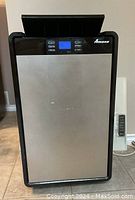 Front view of the Amana portable air conditioner, stainless steel front with black trim, digital display and control buttons visible on top.