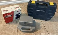 Photo of MasterCraft drill case, JobMate sander in original box, small gray kit case arranged on floor.