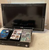 Front view of Panasonic 32-inch LCD TV, Panasonic DVD player underneath, and several DVD cases on display.