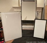 Three whiteboards displayed: a standing easel whiteboard with black bottom tray, large whiteboard with aluminum frame, black frame whiteboard.