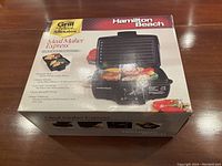 Front view of boxed Hamilton Beach Meal Maker Express Indoor Grill showing grill image and main features.