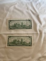 Two 1967 Canadian one dollar bills, back side showing Parliament Hill illustration on each bill