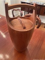 Side view of teak ice cooler showing integrated handle and wood grain finish.